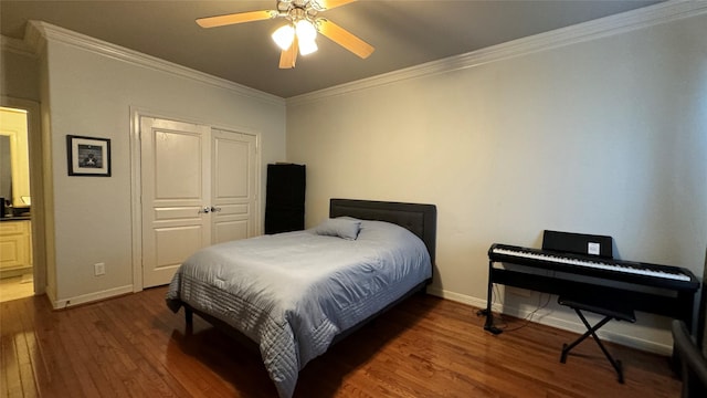 bedroom with dark wood-type flooring, ceiling fan, crown molding, and a closet