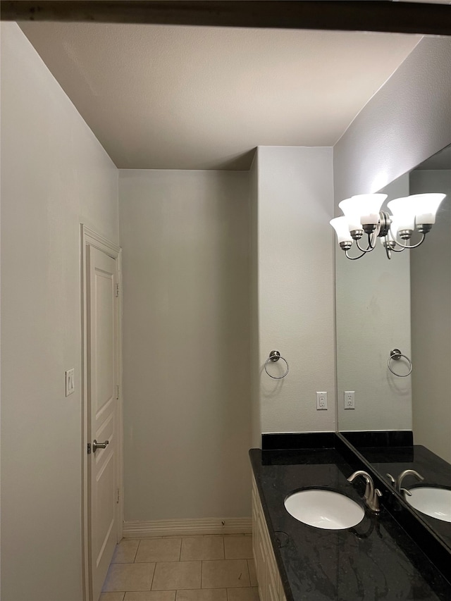 bathroom with an inviting chandelier, tile patterned floors, and vanity