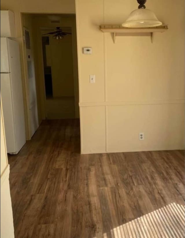 empty room with dark hardwood / wood-style flooring and ceiling fan