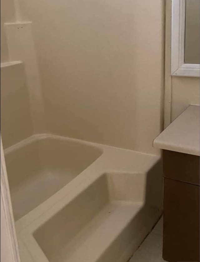 bathroom with vanity and a bath