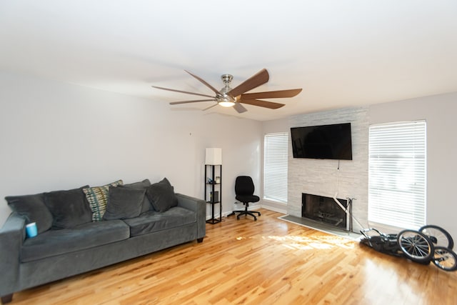 living room featuring a fireplace, ceiling fan, and hardwood / wood-style floors