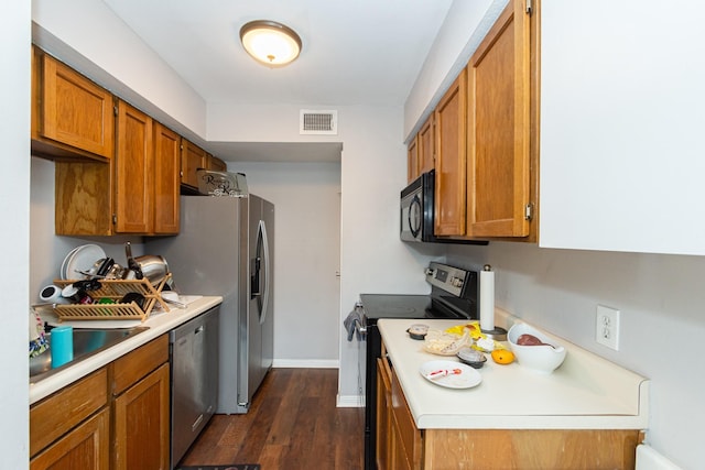 6201 Beverlyhill St Unit 30, Houston, TX 77057 - kitchen featuring appliances with stainless steel finishes, light countertops, brown cabinets, and dark wood finished floors