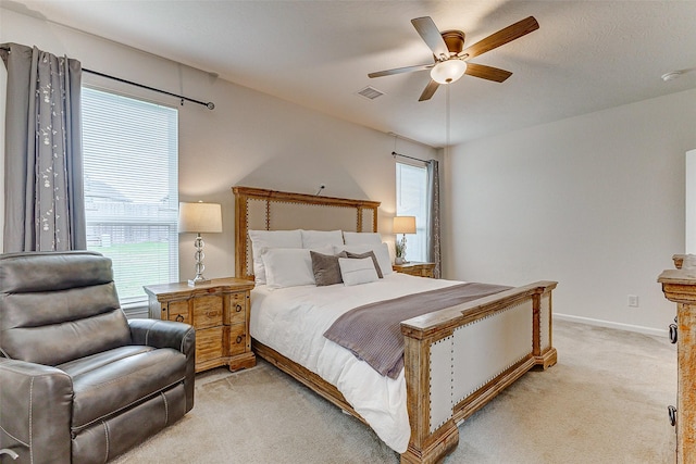 carpeted bedroom with multiple windows and ceiling fan