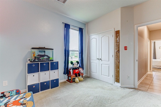 game room with carpet flooring and a textured ceiling