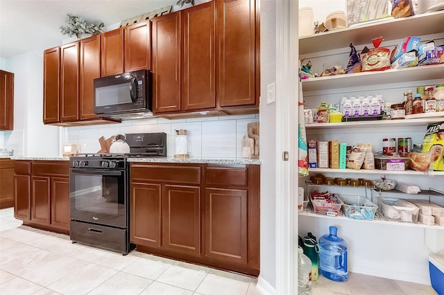 kitchen with backsplash, light stone counters, light tile patterned floors, and black appliances