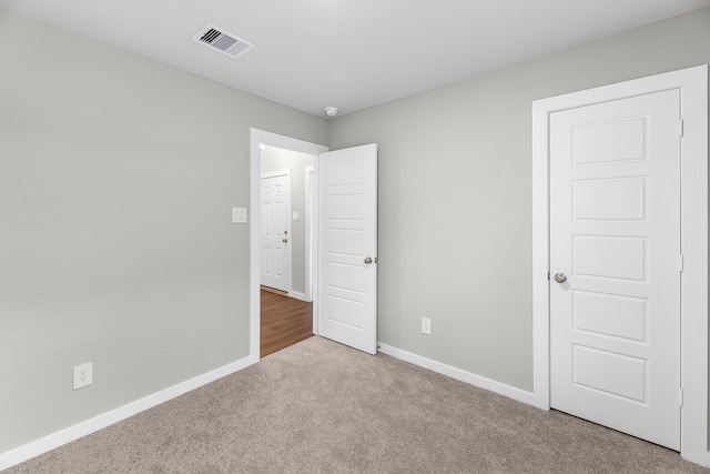 unfurnished bedroom featuring light carpet