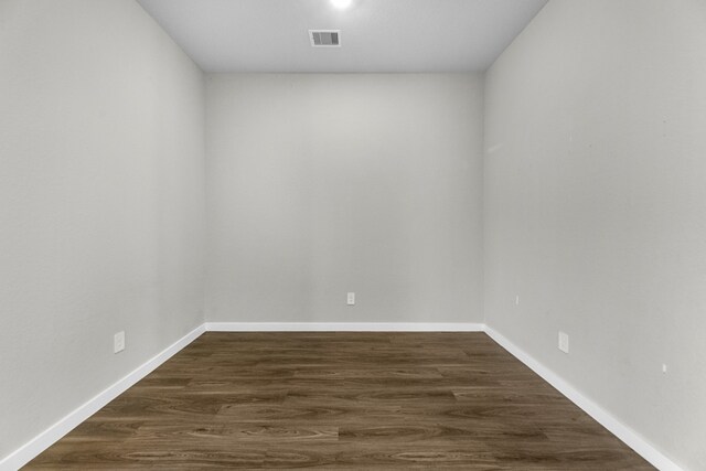 unfurnished room with dark hardwood / wood-style flooring