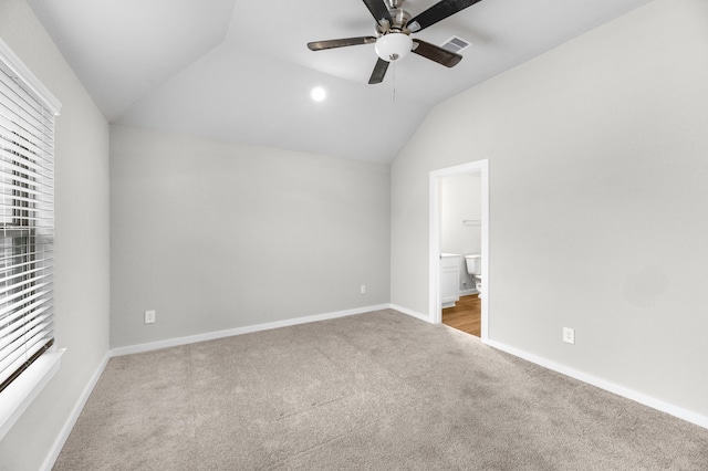 unfurnished bedroom with ceiling fan, connected bathroom, lofted ceiling, and carpet floors