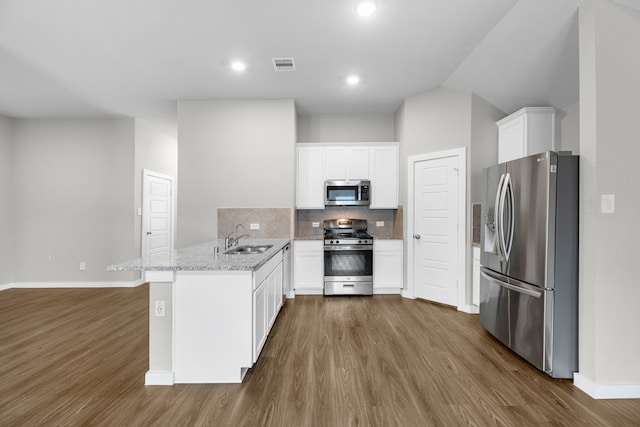 kitchen with white cabinets, kitchen peninsula, stainless steel appliances, and sink