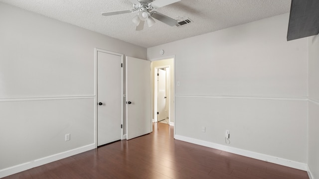 unfurnished bedroom featuring dark hardwood / wood-style flooring, a textured ceiling, and ceiling fan