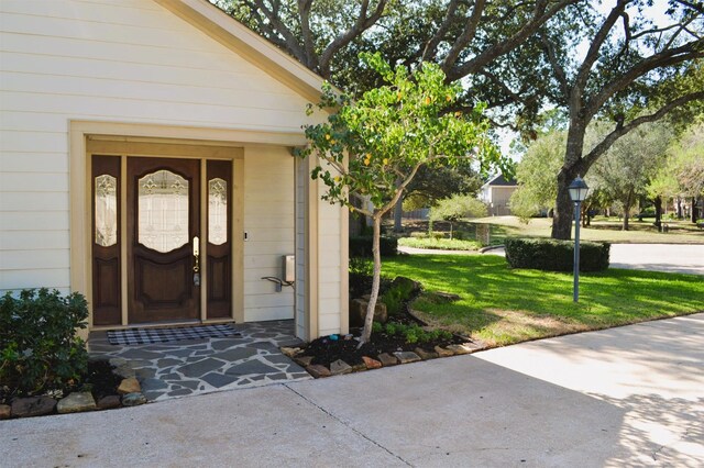 entrance to property featuring a lawn