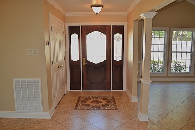 tiled foyer entrance featuring ornate columns and ornamental molding