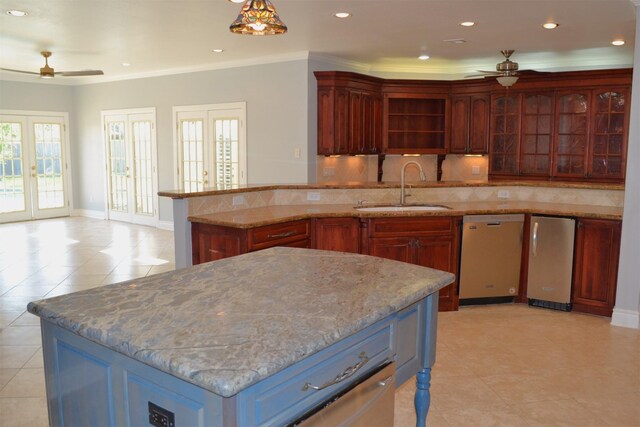 kitchen with french doors, sink, tasteful backsplash, a kitchen island with sink, and ceiling fan