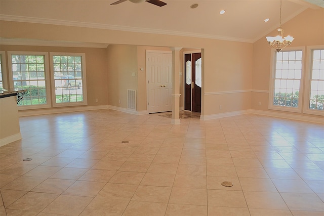 empty room featuring light tile patterned flooring, plenty of natural light, vaulted ceiling, and crown molding