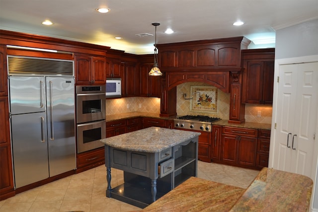 kitchen with stainless steel appliances, light stone countertops, decorative light fixtures, a center island, and decorative backsplash