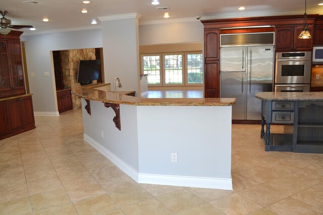 kitchen with light stone counters, appliances with stainless steel finishes, ceiling fan, crown molding, and pendant lighting