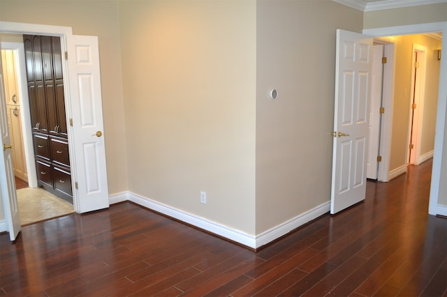 spare room featuring ornamental molding and dark wood-type flooring