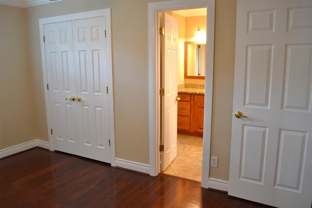 interior space featuring dark wood-type flooring, a closet, and ornamental molding