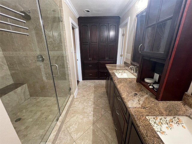 bathroom with tile patterned floors, vanity, a shower with door, and crown molding