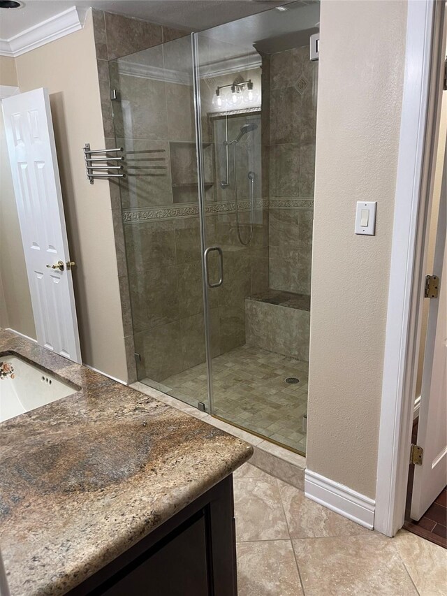 bathroom with ornamental molding, vanity, tile patterned floors, and a shower with door