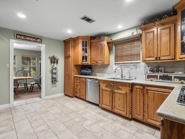 kitchen with backsplash, a textured ceiling, sink, dishwasher, and light tile patterned flooring