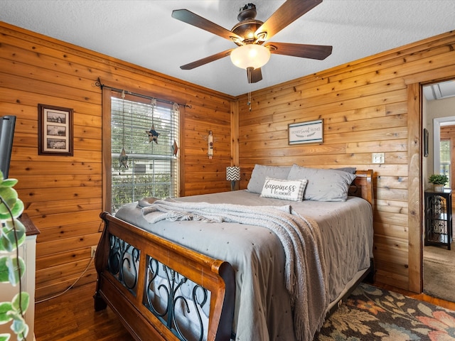 bedroom with ceiling fan and wood walls