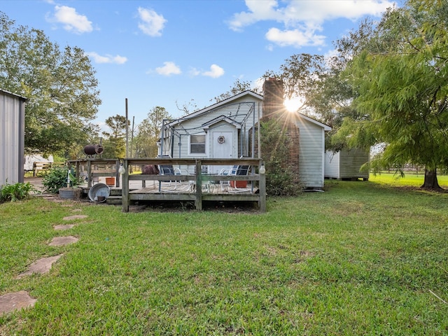 rear view of house featuring a yard and a wooden deck