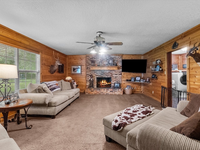 living room featuring wood walls, carpet, a textured ceiling, and a brick fireplace