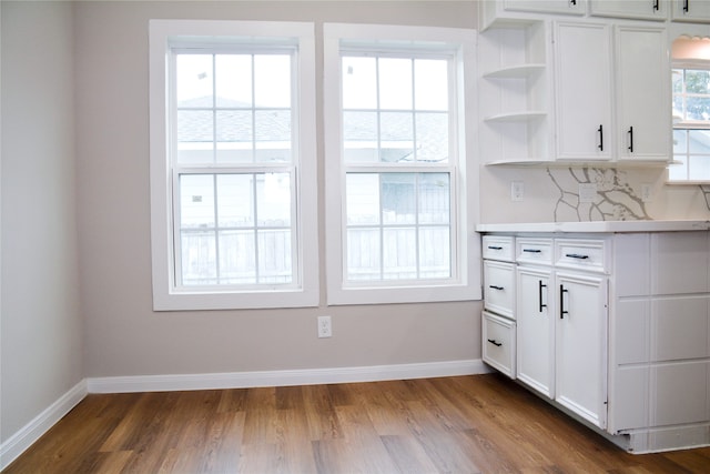 kitchen featuring dark wood-type flooring, a wealth of natural light, and white cabinets