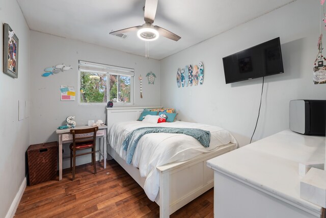 bedroom with visible vents, wood finished floors, a ceiling fan, and baseboards