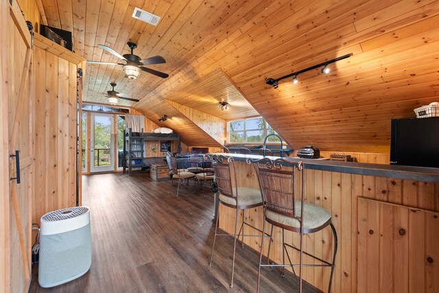 interior space with dark wood-style flooring, lofted ceiling, visible vents, track lighting, and wooden ceiling