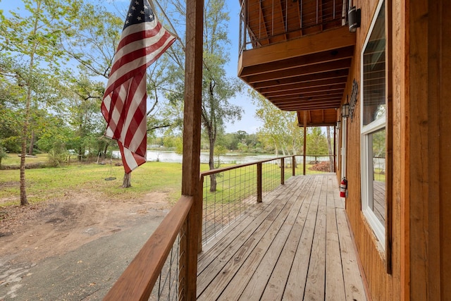 deck featuring a lawn and a water view