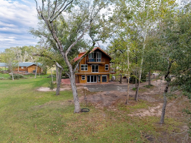 rear view of house featuring a patio and a yard