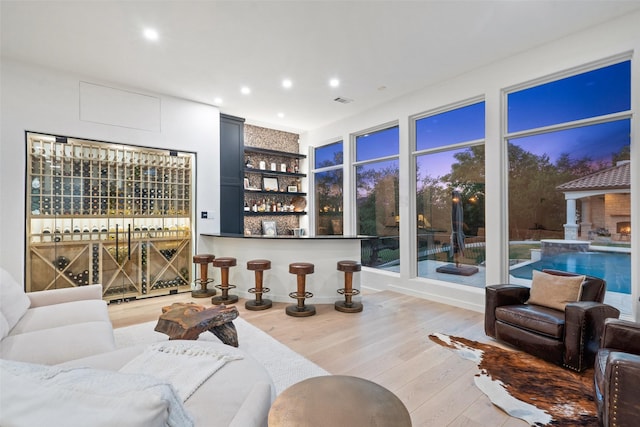 living room with hardwood / wood-style floors and indoor bar