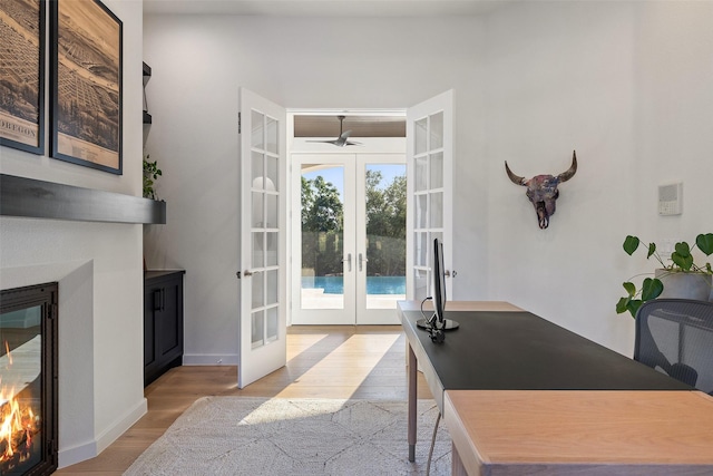 office area with ceiling fan, french doors, and light hardwood / wood-style floors