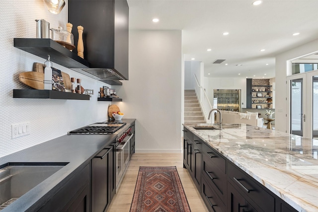 kitchen featuring light stone counters, sink, light hardwood / wood-style flooring, and gas cooktop