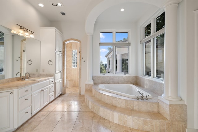 bathroom featuring tile patterned flooring, shower with separate bathtub, vanity, and decorative columns