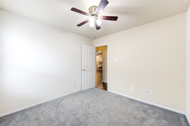 carpeted spare room with ceiling fan