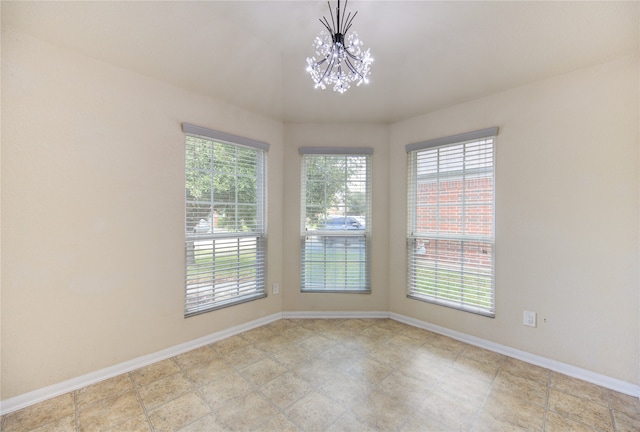 empty room featuring a wealth of natural light and an inviting chandelier