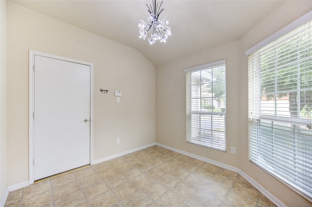 unfurnished room featuring an inviting chandelier and vaulted ceiling