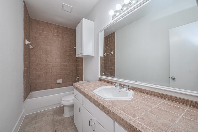 full bathroom featuring toilet, tiled shower / bath combo, vanity, and tile patterned floors