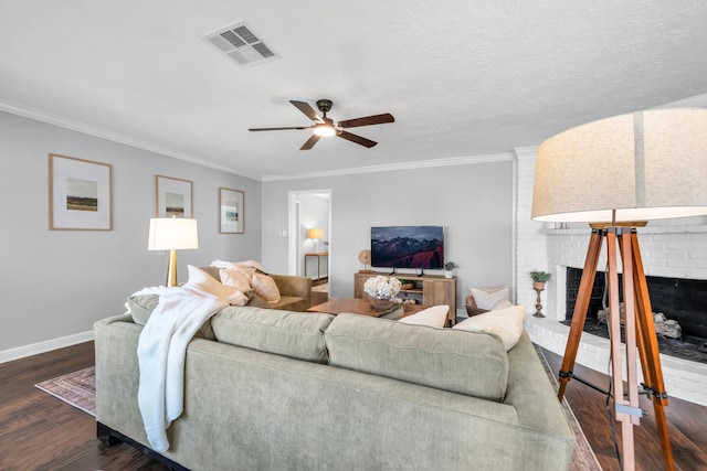 living room with ceiling fan, crown molding, dark hardwood / wood-style floors, and a brick fireplace