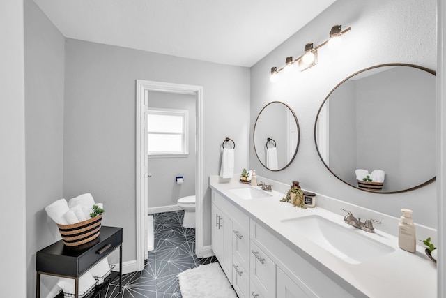 bathroom featuring toilet, vanity, and tile patterned floors