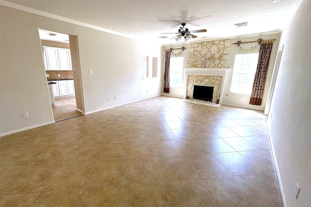 unfurnished living room with a stone fireplace, light tile patterned floors, a textured ceiling, ornamental molding, and ceiling fan