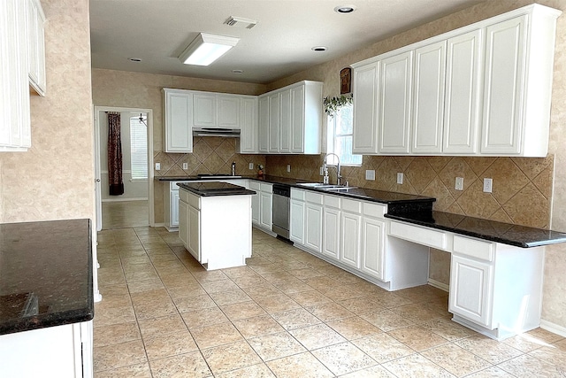 kitchen featuring stainless steel appliances, white cabinetry, backsplash, and a kitchen island