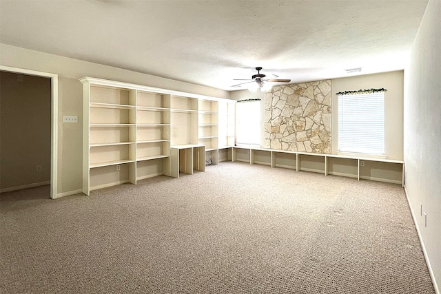 unfurnished living room featuring a textured ceiling, ceiling fan, and carpet floors