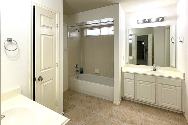 bathroom with vanity, tiled shower / bath, and tile patterned flooring