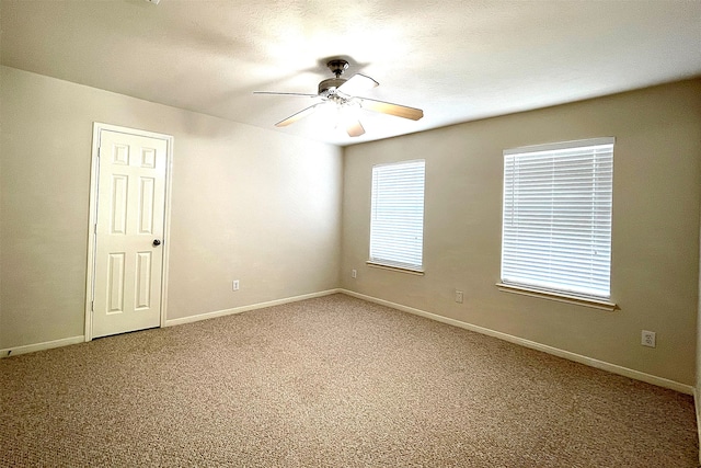 spare room featuring ceiling fan and carpet flooring