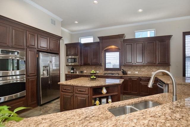 kitchen with light stone countertops, dark brown cabinetry, sink, and appliances with stainless steel finishes