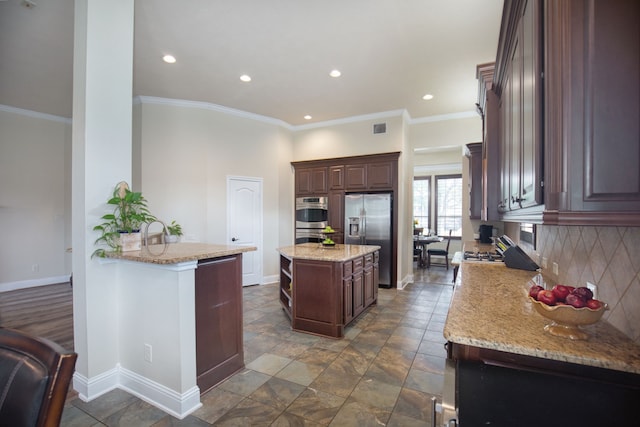 kitchen featuring a center island, stainless steel appliances, light stone counters, backsplash, and ornamental molding